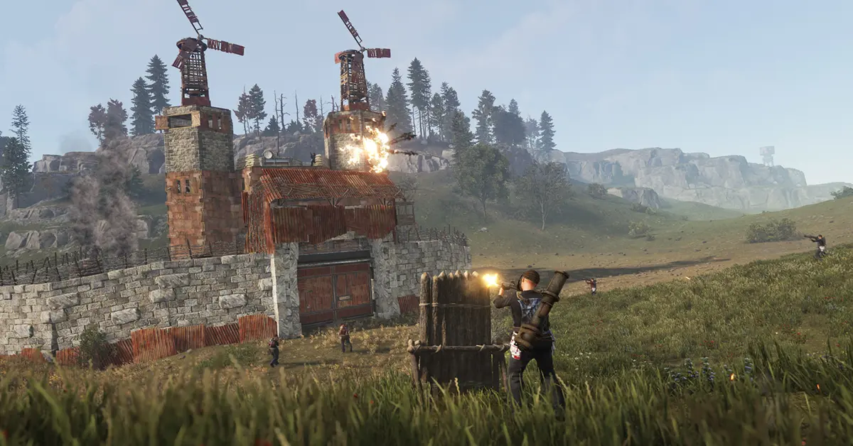 Un jugador está de pie fuera de una base de metal fortificada en Rust, sosteniendo un rifle de asalto fabricado al amanecer.